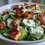 Vibrant Creamy Asian Cucumber Salad with Crispy Tofu topped with golden sesame seeds