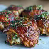 A smoky spice blend coats these juicy, oven-baked chicken thighs, served with parsley garnish for a rustic dinner.  
