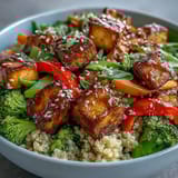 A vibrant bowl of Quinoa Vegetable Teriyaki Bowl features golden crispy tofu and colorful crisp vegetables over fluffy quinoa.  