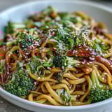 Freshly steamed broccoli and carrots mingle with chewy noodles in a glossy Asian teriyaki glaze for a vibrant bowl.