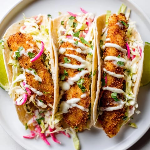 Tender, flaky grilled fish tacos served with fresh lime wedges for a burst of flavor.