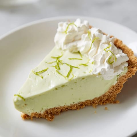 A slice of creamy, luscious Key Lime Pie topped with freshly whipped cream.