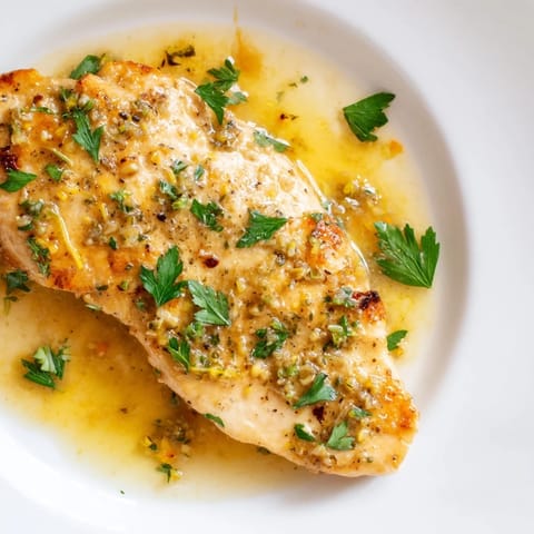 Pan-seared Lemon Pepper Chicken with a buttery, zesty sauce, plated alongside fluffy rice and a crisp green salad.
