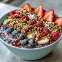 Vibrant Acai Berry Smoothie Bowl topped with sliced banana and berries in a bowl.